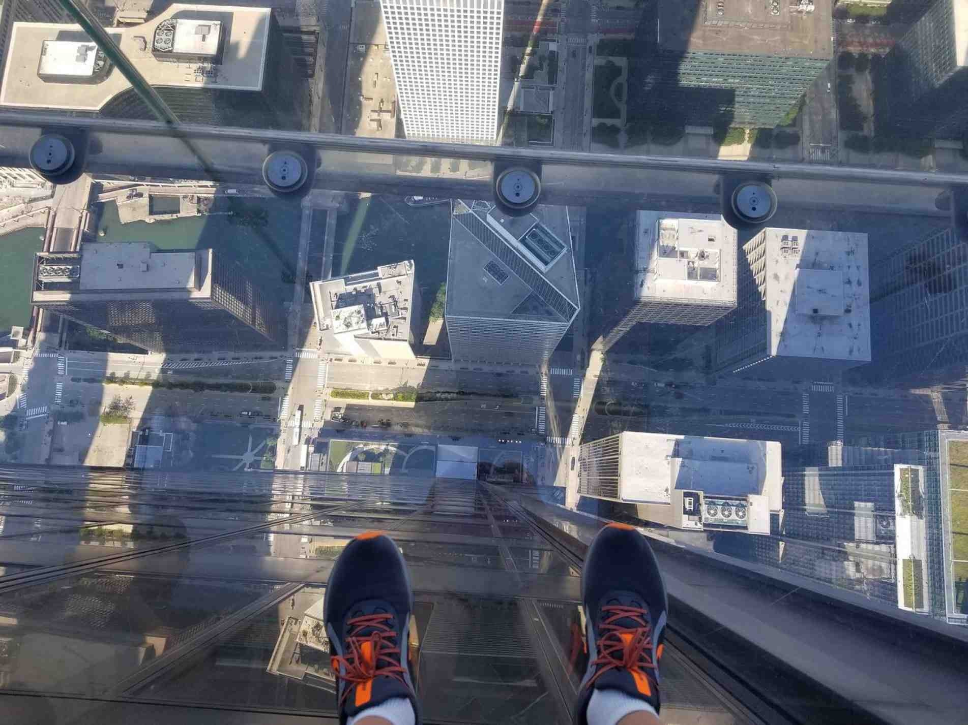 Duas cabines com chão de vidro que avançam os limites dos janelões do edifício.