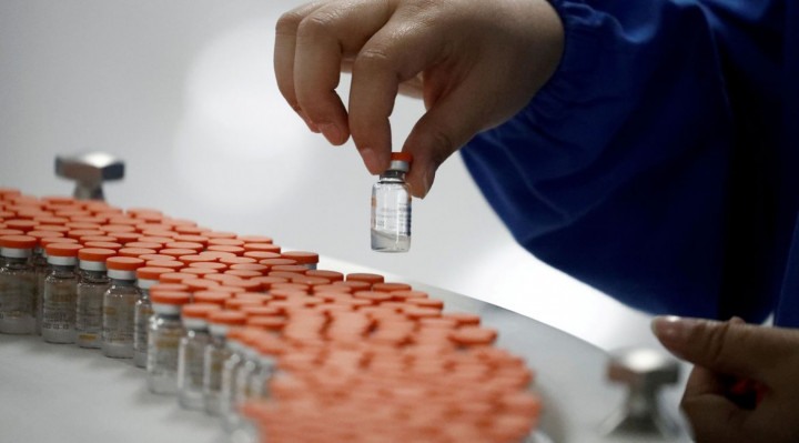 FILE PHOTO: A worker performs a quality check in the packaging facility of Chinese vaccine maker Sinovac Biotech, developing an experimental coronavirus disease (COVID-19) vaccine, during a government-organized media tour in Beijing, China, September 24, 2020. REUTERS/Thomas Peter/File Photo