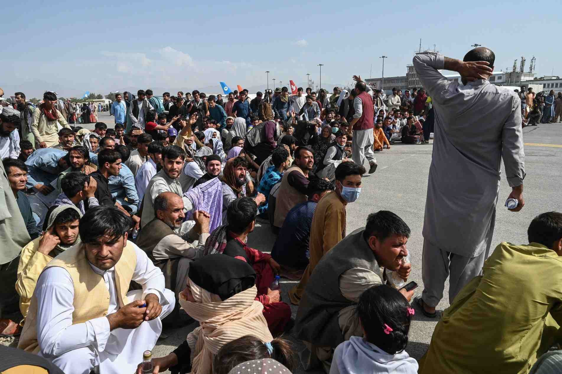 Afegãos esperam no aeroporto de Cabul por uma chance de embarcar para fora do país