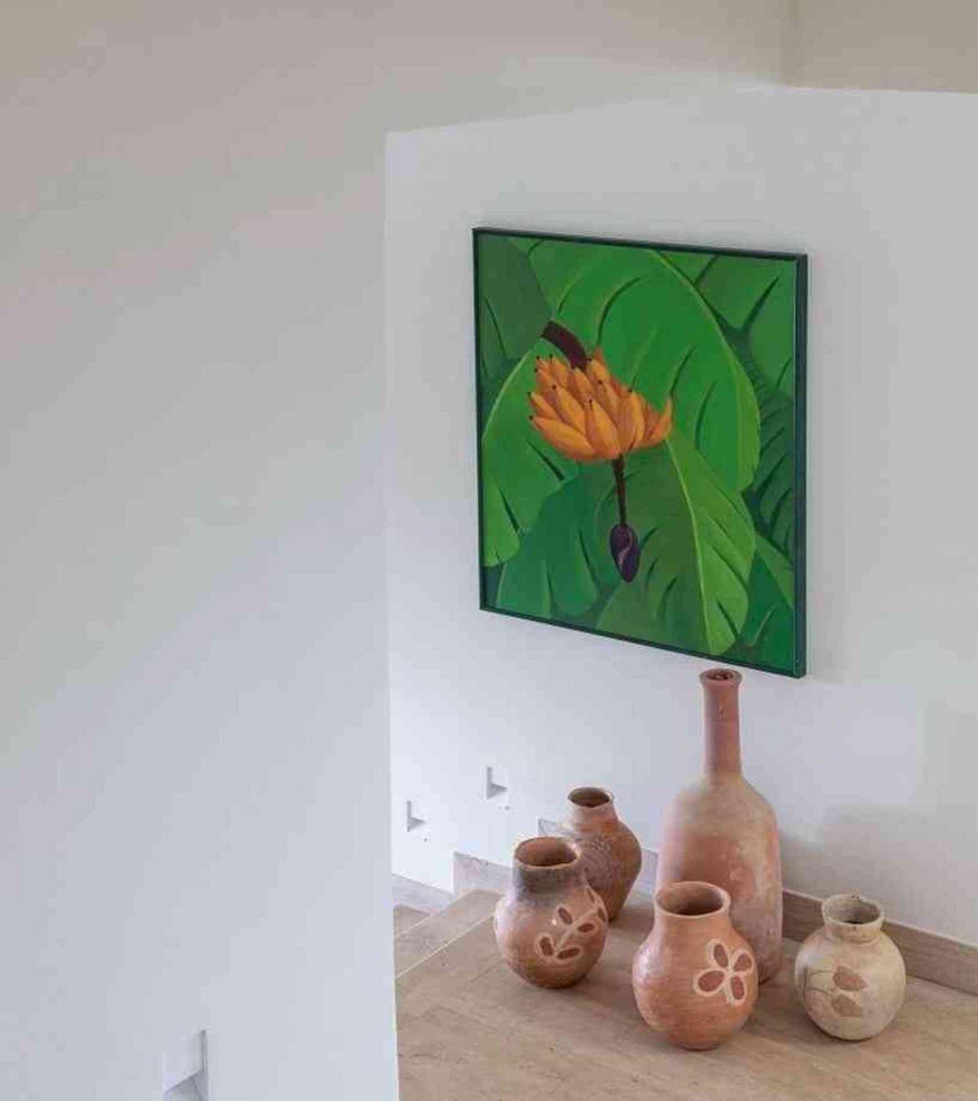 O quadro, em tons de verde e amarelo e a pintura de uma bananeira, trouxe um toque de cor para a passagem.