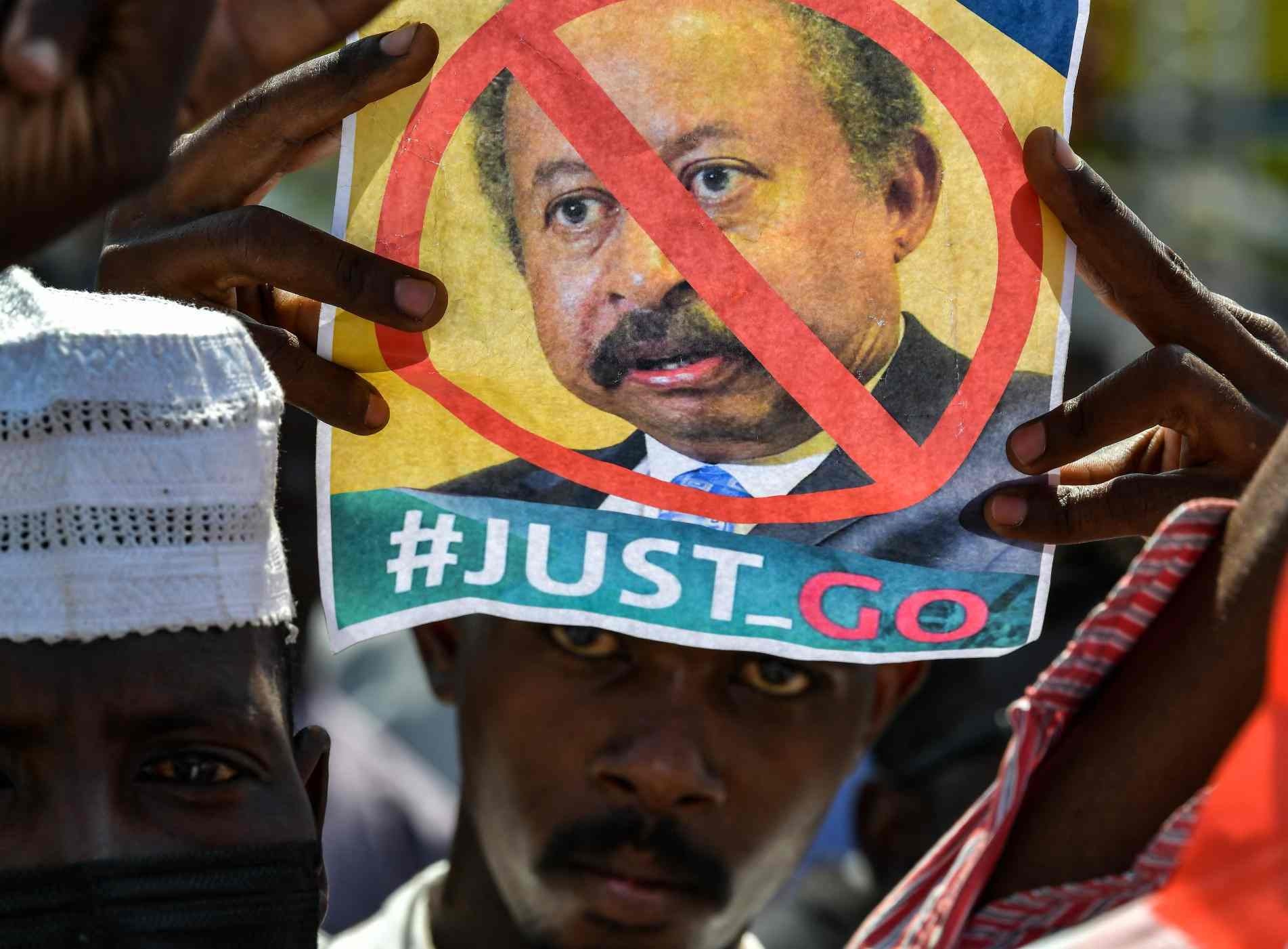 Um sudanês segura um cartaz contra o primeiro-ministro