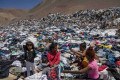 Mulheres procuram roupas em meio a descarte em Alto Hospicio, no deserto do Atacama - Foto: Martin Bernetti/AFP
