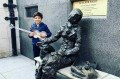 O pequeno em Liverpool, junto à estátua de uma idosa solitária feita em homenagem à música "Eleanor Rigby". - DIVULGAÇÃO