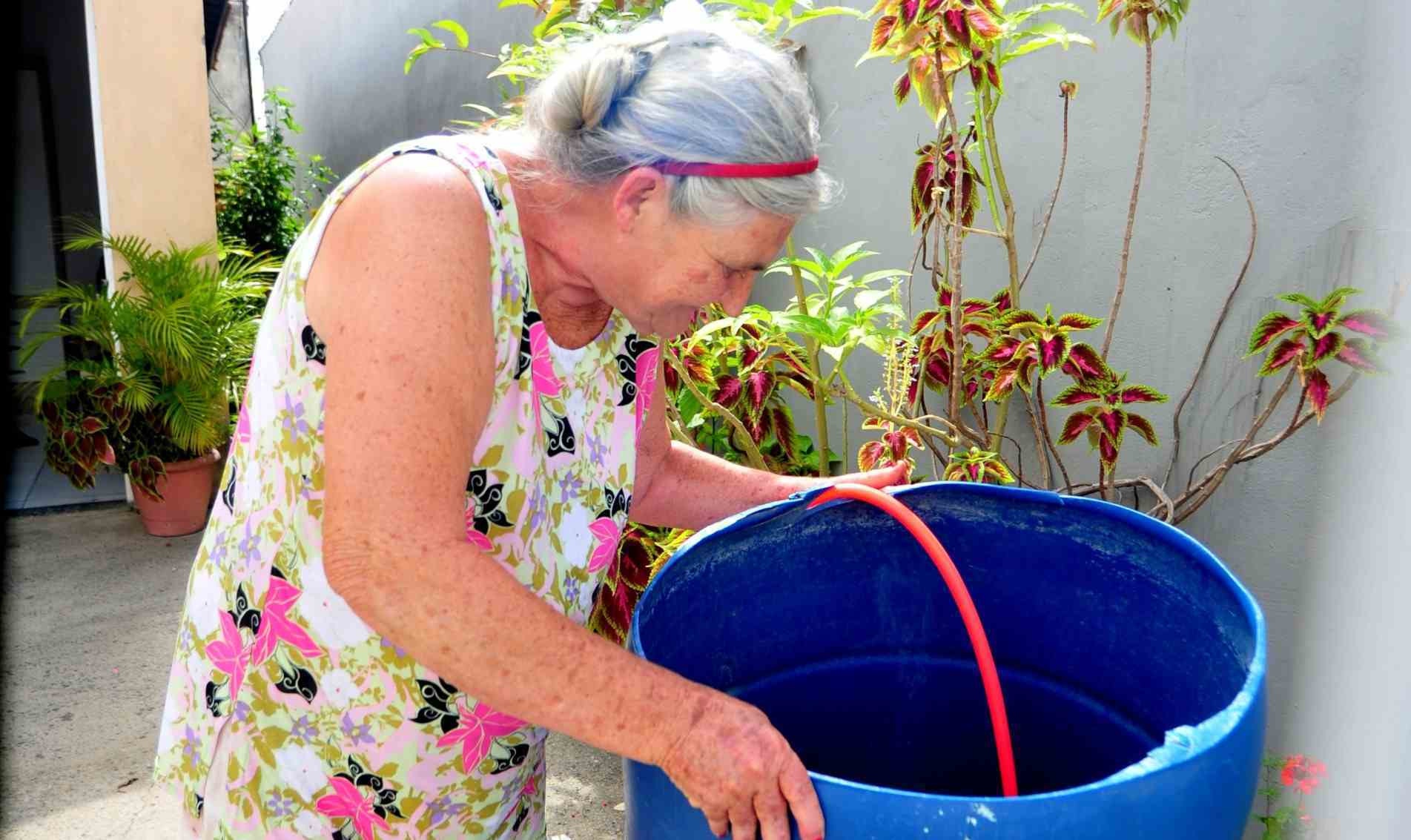 Maria Gasparina de Oliveira armazena água em galões para enfrentar o racionamento.