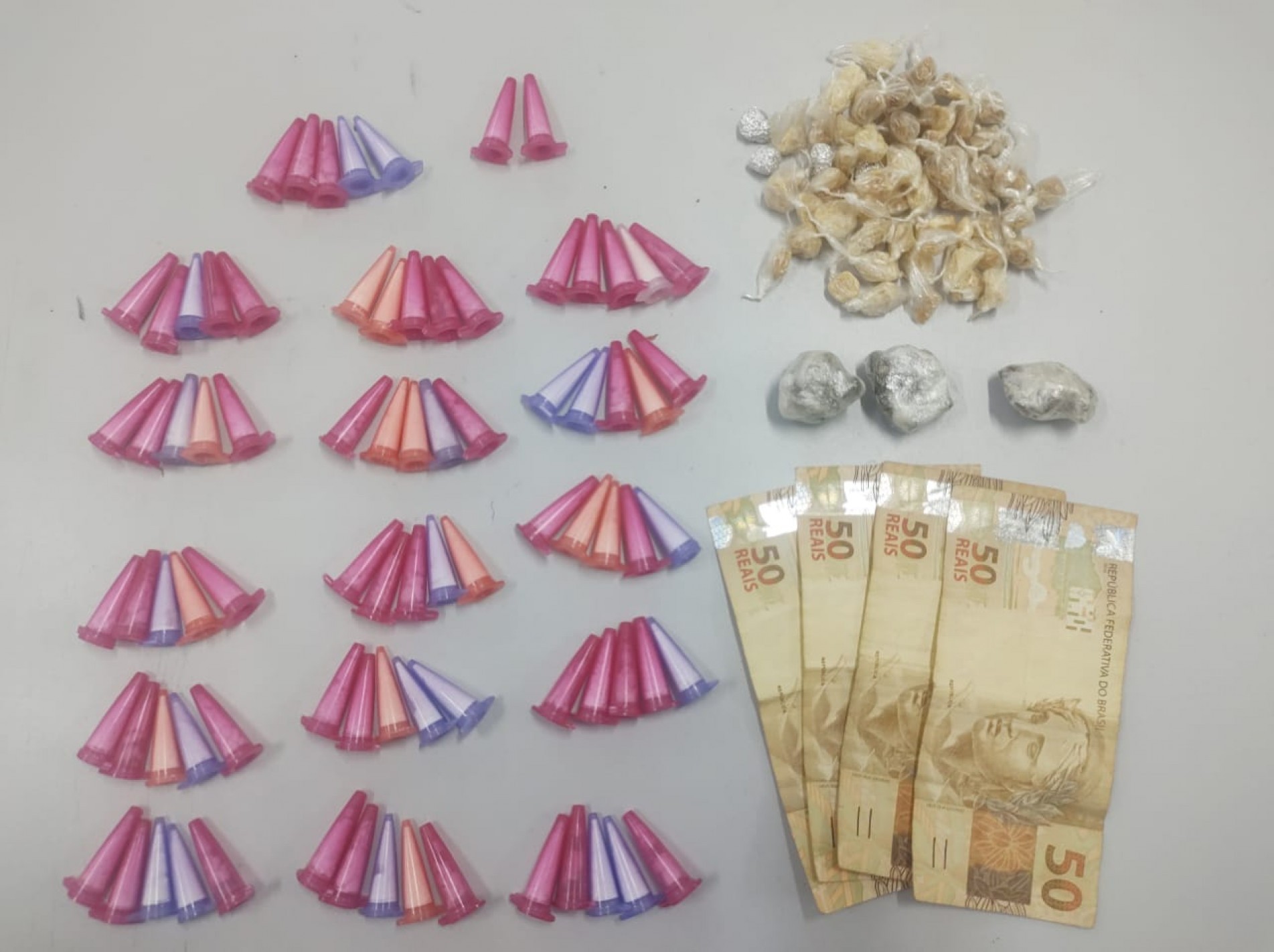 Foram encontrados 82 pinos de cocaína, 68 pedras de crack, três porções de maconha e a quantia de R$200,00 em dinheiro