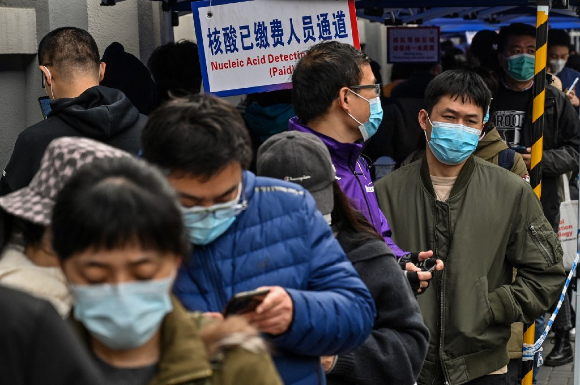 Pessoas fazem fila para serem testadas como medida contra o coronavírus em Xangai