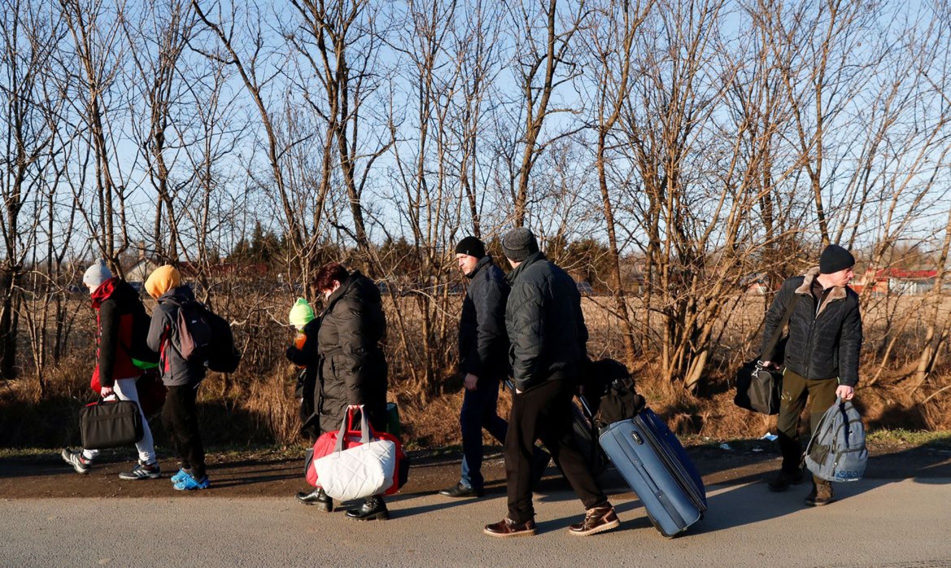  People carry their luggage as they flee from Ukraine at the Hungarian-Ukrainian border after Russian President Vladimir Putin authorized a military operation, in Tiszabecs, Hungary, February 24, 2022. REUTERS/Bernadett Szabo..
    