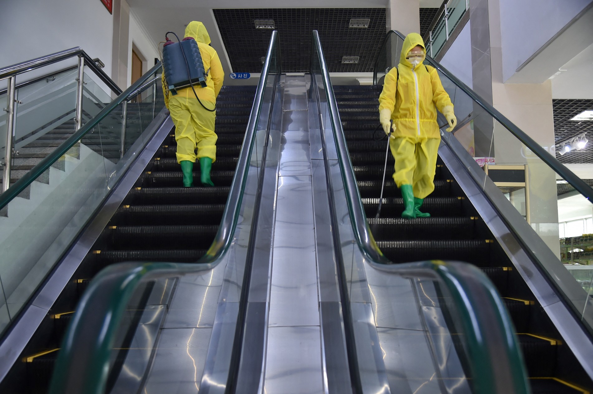  (FILES) In this file photo taken on March 18, 2022 employees spray disinfectant as part of preventative measures against the Covid-19 coronavirus at the Pyongyang Children's Department Store in Pyongyang. - North Korea on May 12, 2022 confirmed its first-ever case of Covid-19, with state media declaring it a 