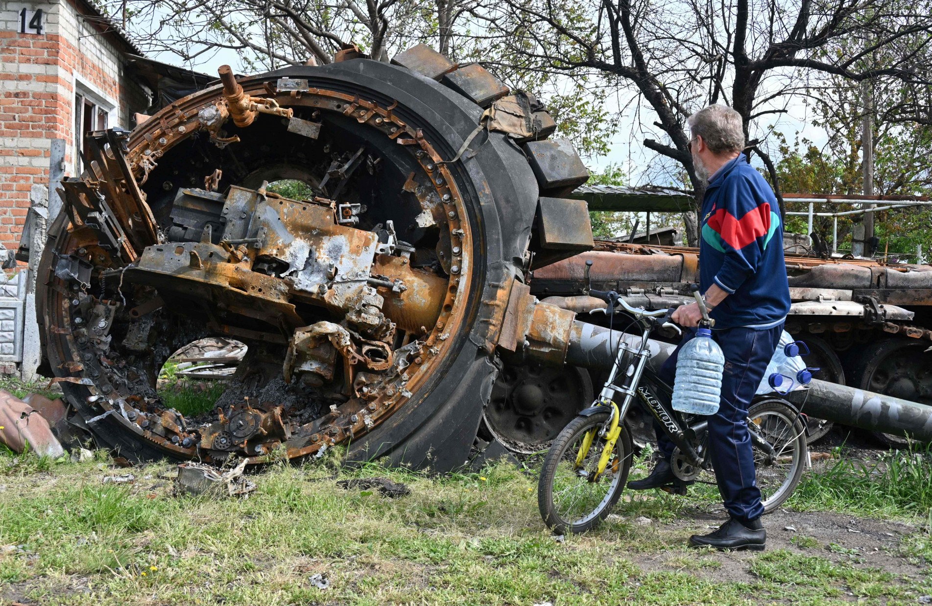 Ucraniano observa tanque russo destruído em Kharkiv.