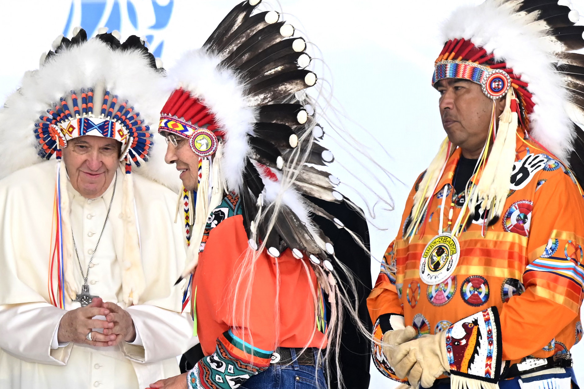  Pope Francis wears a headdress presented to him by Indigenous leaders at Muskwa Park in Maskwacis, Alberta, Canada, on July 25, 2022. - Pope Francis will make a historic personal apology Monday to Indigenous survivors of child abuse committed over decades at Catholic-run institutions in Canada, at the start of a week-long visit he has described as a 