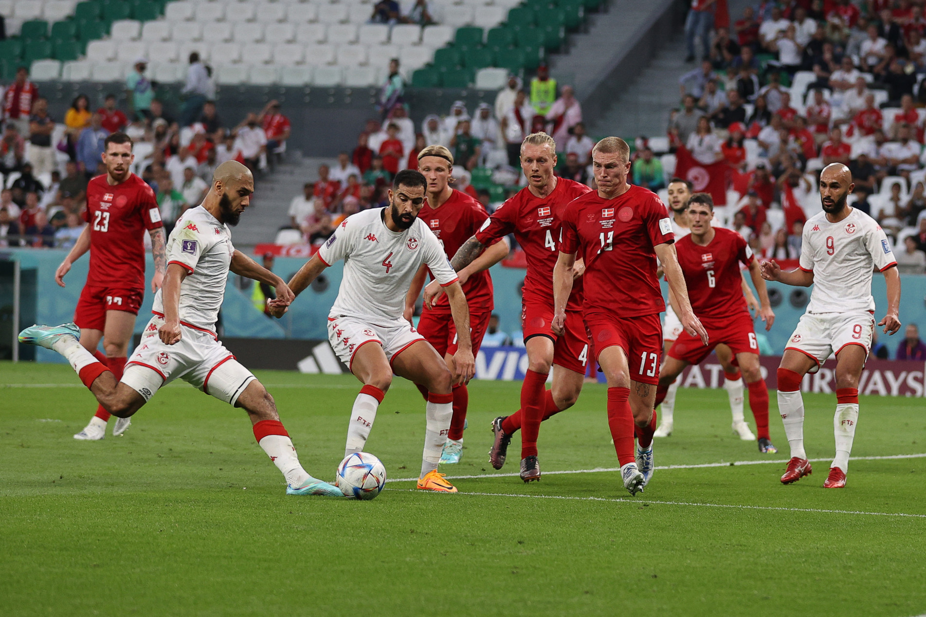  Tunisia's midfielder #14 Aissa Laidouni (L) shoots but fails to score during the Qatar 2022 World Cup Group D football match between Denmark and Tunisia at the Education City Stadium in Al-Rayyan, west of Doha on November 22, 2022. (Photo by ADRIAN DENNIS / AFP)