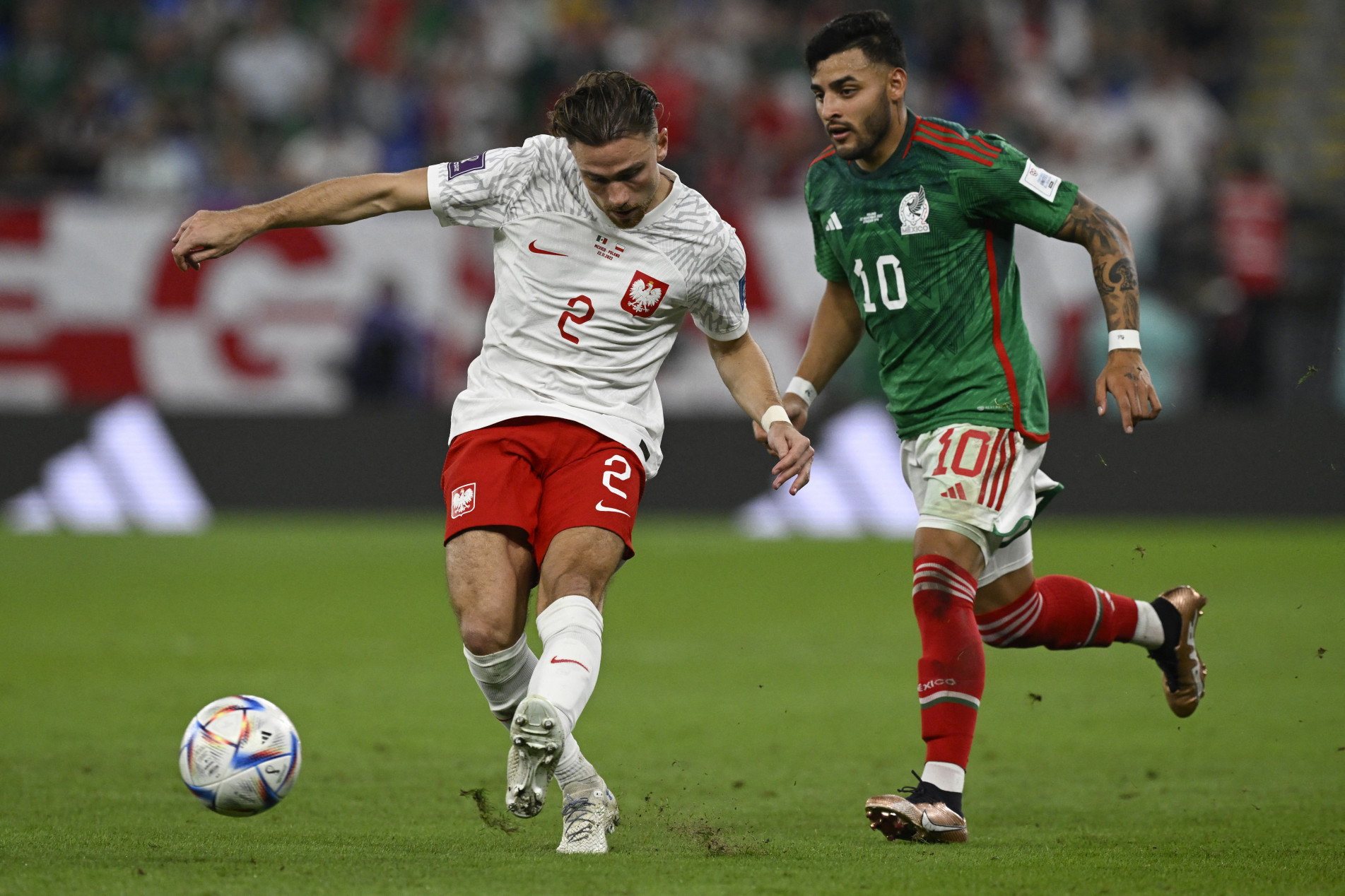  Poland's defender #02 Matthew Cash (L) fights for the ball with Mexico's forward #10 Alexis Vega during the Qatar 2022 World Cup Group C football match between Mexico and Poland at Stadium 974 in Doha on November 22, 2022. (Photo by Alfredo ESTRELLA / AFP)