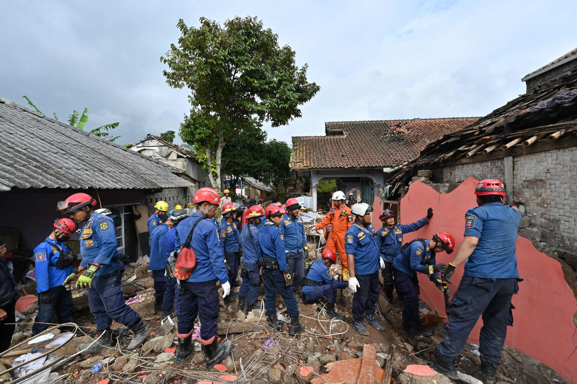  Rescue personnel work to find a missing child believed to be trapped in the rubble of a collapsed house at Cugenang in Cianjur, West Java on November 24, 2022, following a 5.6-magnitude earthquake on November 21. - Survivors of an Indonesian earthquake that killed at least 271 people, many of them children, appealed for food and water November 23 as heavy rain and aftershocks hampered rescue efforts among the rubble of devastated villages. (Photo by ADEK BERRY / AFP)