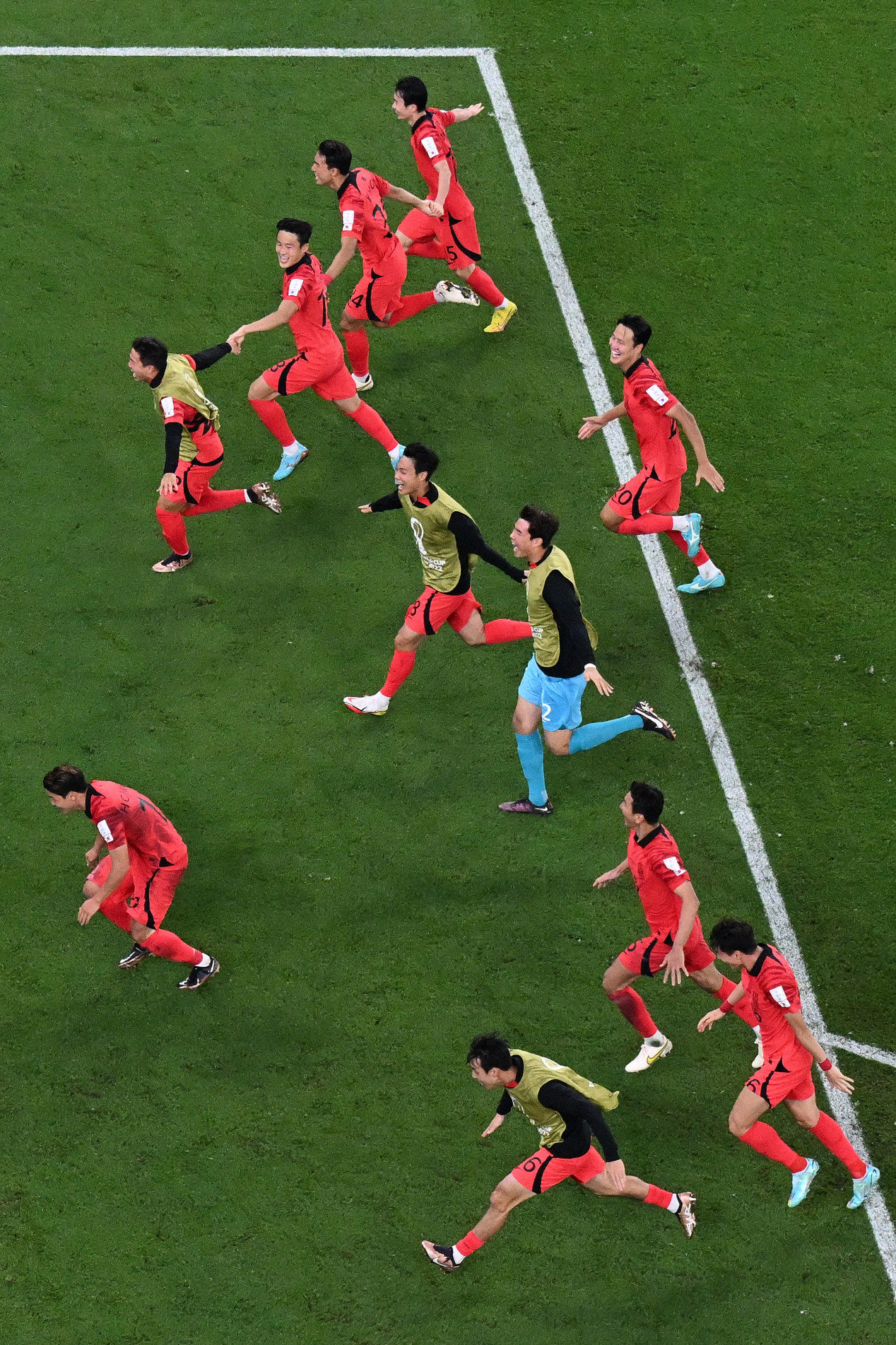  South Korea's players celebrate qualifying for the World Cup last 16 at the end of the Qatar 2022 World Cup Group H football match between South Korea and Portugal at the Education City Stadium in Al-Rayyan, west of Doha on December 2, 2022. (Photo by Kirill KUDRYAVTSEV / AFP)