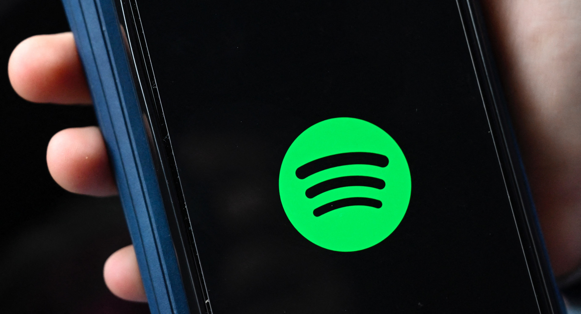  The company logo of Swedish music streaming giant spotify is pictured on a smartphone in Berlin on January 23, 2023. - Swedish music streaming giant Spotify said on January 23, 2023 that it was cutting six percent of its roughly 10,000 employees, the latest among a slew of cost-cutting announcements by technology companies. (Photo by Tobias Schwarz / AFP)