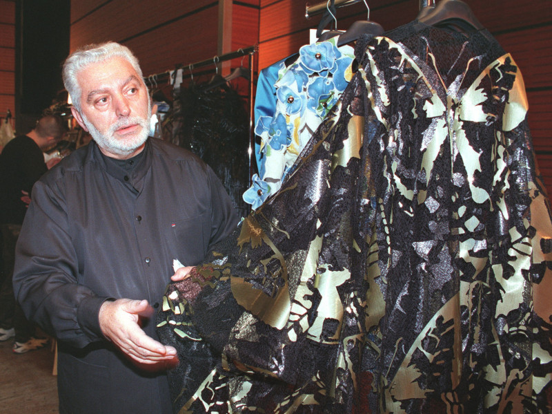  (FILES) In this file photo taken on January 20, 1999, Spanish Designer Paco Rabanne checks a dress before his 1999 Spring/Summer haute-couture collection, in Paris. - Spanish fashion designer Paco Rabanne, known for his eccentric clothing designs and for founding one of the world's best-known fragrance brands, died on Friday at the age of 88. Rabanne's death was confirmed to AFP by the parent company of his brand, who said he had 