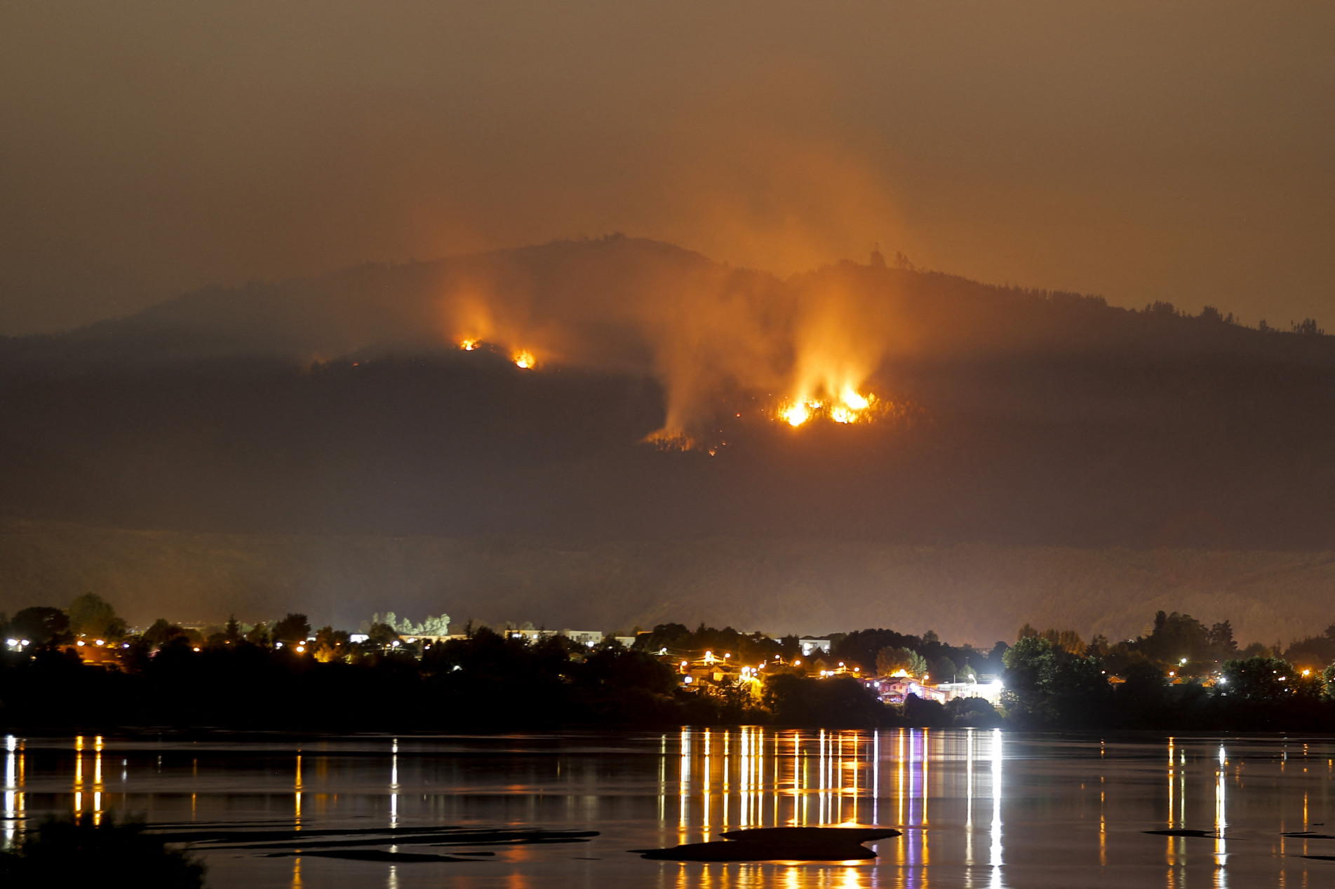  A forest fire approaches the town of Chiguayante, in the province of Concepcion, Chile, on February 9, 2023. - Forecasts of persistent high temperatures and strong winds bode ill Wednesday, February 8, 2023, for drought-stricken Chile as dozens of forest fires -- several of them deadly -- showed no signs of abating.
More than 5,600 local firefighters, with backup from personnel flown in from Mexico, Colombia and Spain, were actively battling 89 priority fires out of a total of 311 burning a week into the disaster, officials said. (Photo by JAVIER TORRES / AFP)
      Caption