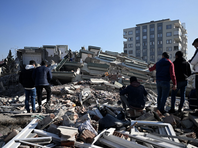  People and rescuers carry out search operations among the rubble of collapsed buildings in Kahramanmaras, on February 9, 2023, three days after a 7,8-magnitude earthquake struck southeast Turkey. - The death toll from a huge earthquake that hit Turkey and Syria climbed to more than 17,100 on February 9, as hopes faded of finding survivors stuck under rubble in freezing weather. (Photo by OZAN KOSE / AFP)