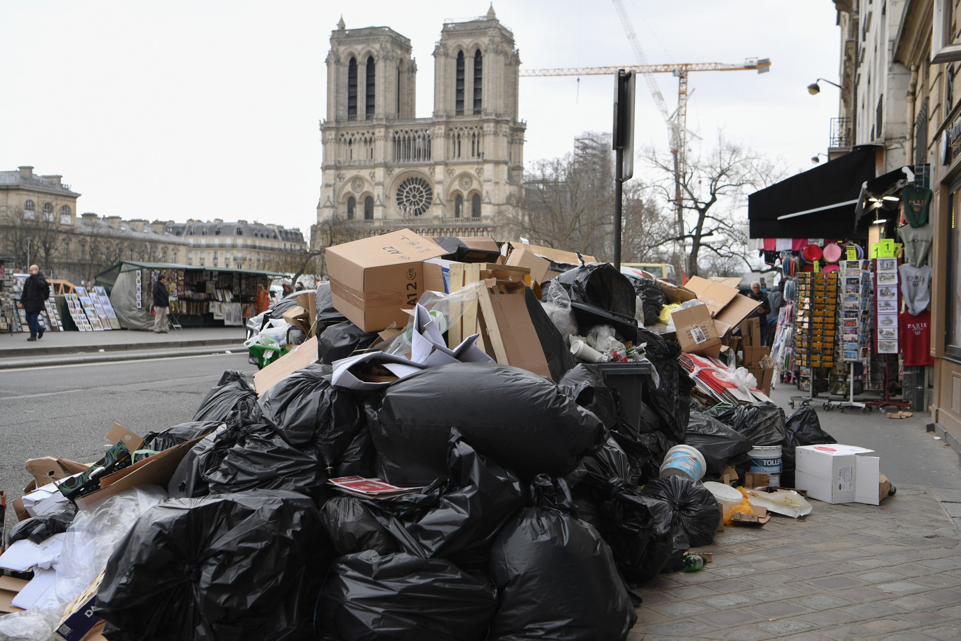  A photograph taken on March 17, 2023 in Paris' 4th district, shows rubbish on a street near Notre Dame Cathedral as rubbish collectors strike against pension reforms, leaving many streets in the capital piled with stinking waste. - France forced Paris rubbish collectors to return to work after a days-long strike against pension reforms. Workers walked off the job in protest against President Emmanuel Macron's plans to reform the pension system, with headline measures of raising the legal retirement age to 64 and increasing the number of years people must pay in to receive a full pension. (Photo by Bertrand GUAY / AFP)