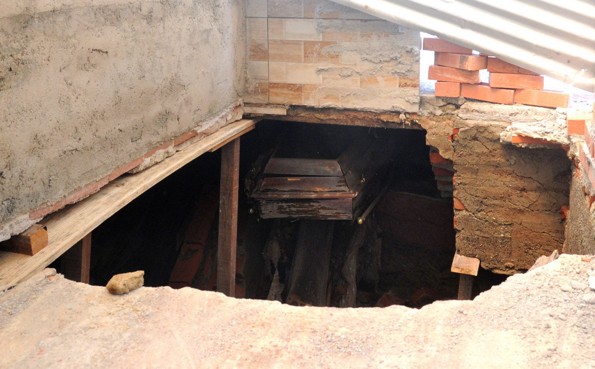 Estrutura de alvenaria cederam, deixando caixões e ossadas à amostra
