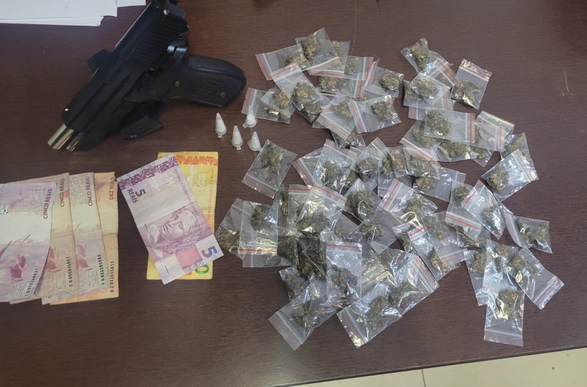 Com os homem e o adolescente, foram apreendidas 153 porções de drogas, uma réplica de arma, R$ 100 em dinheiro e celulares