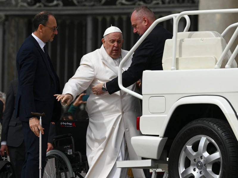  Pope Francis is helped get up the popemobile car as he leaves on March 29, 2023 at the end of the weekly general audience at St. Peter's square in The Vatican. - Pope Francis has been at the Gemelli Hospital in Rome since the afternoon of March 29, 2023 for some previously scheduled check-ups, the Holy See press director said. (Photo by Vincenzo PINTO / AFP)