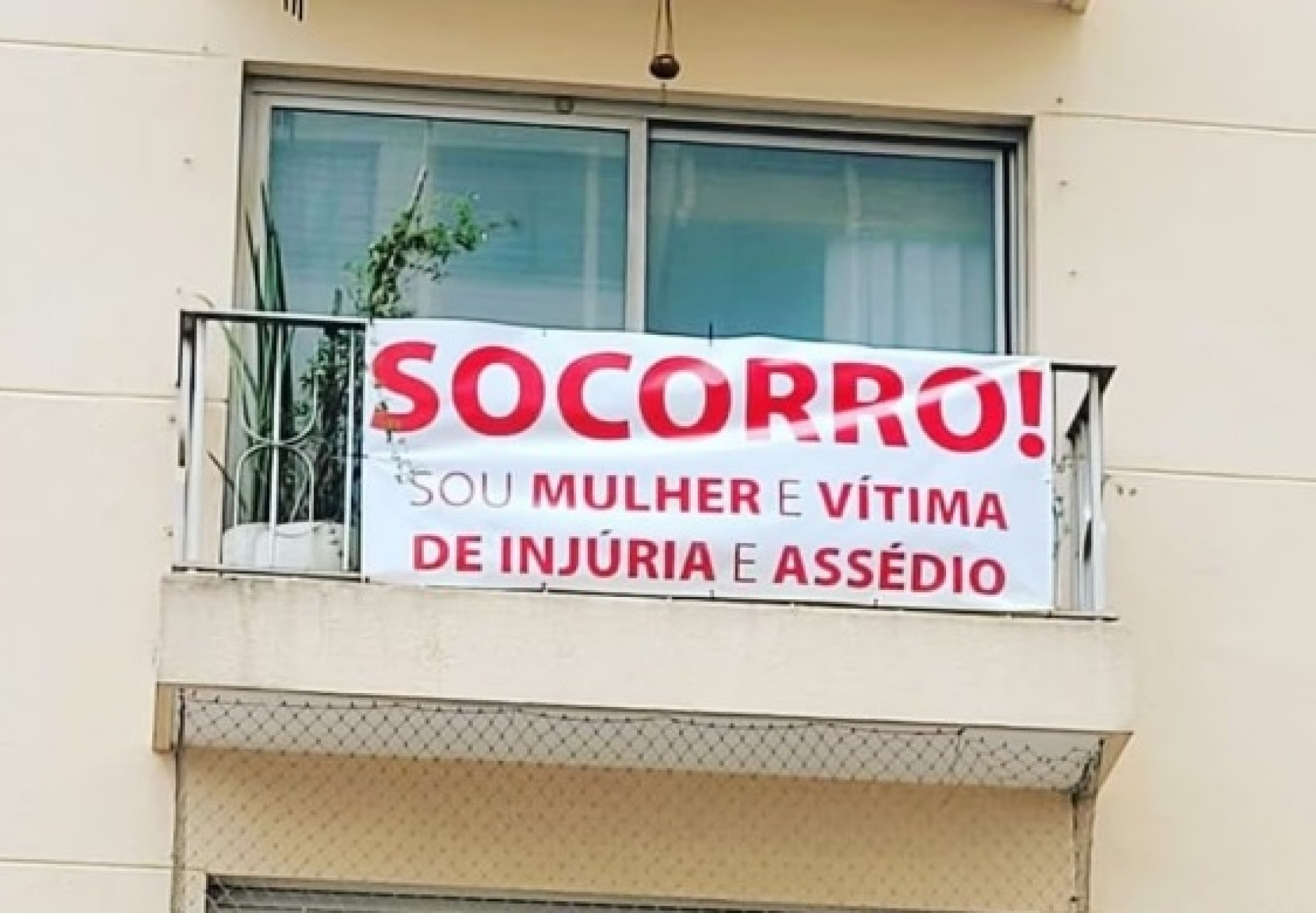 Faixa com pedido de socorro contra assédio de vizinho foi colocada em janela de apartamento, na capital paulista