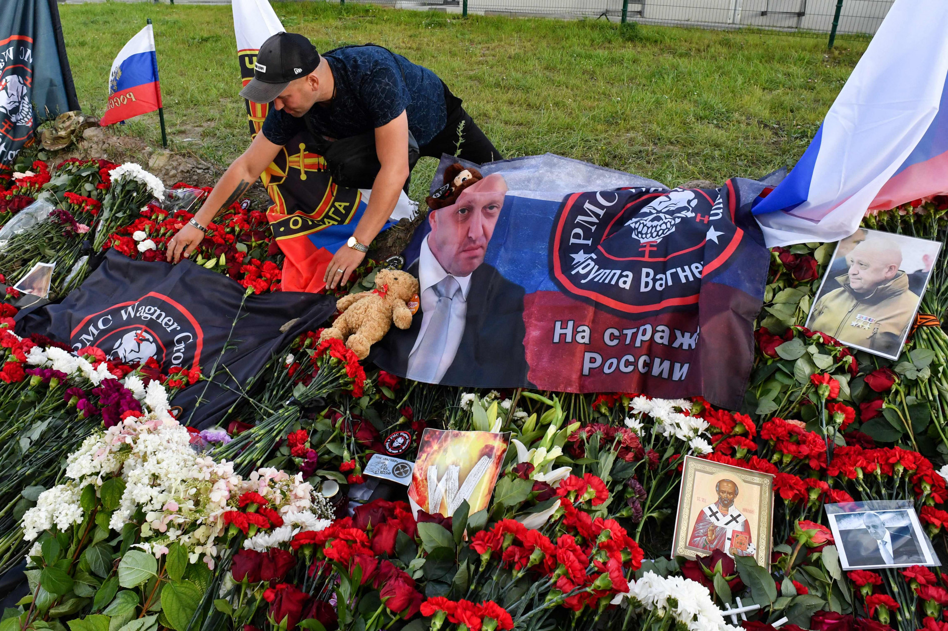 Homem ajeita bandeira do grupo Wagner em São Petersburgo