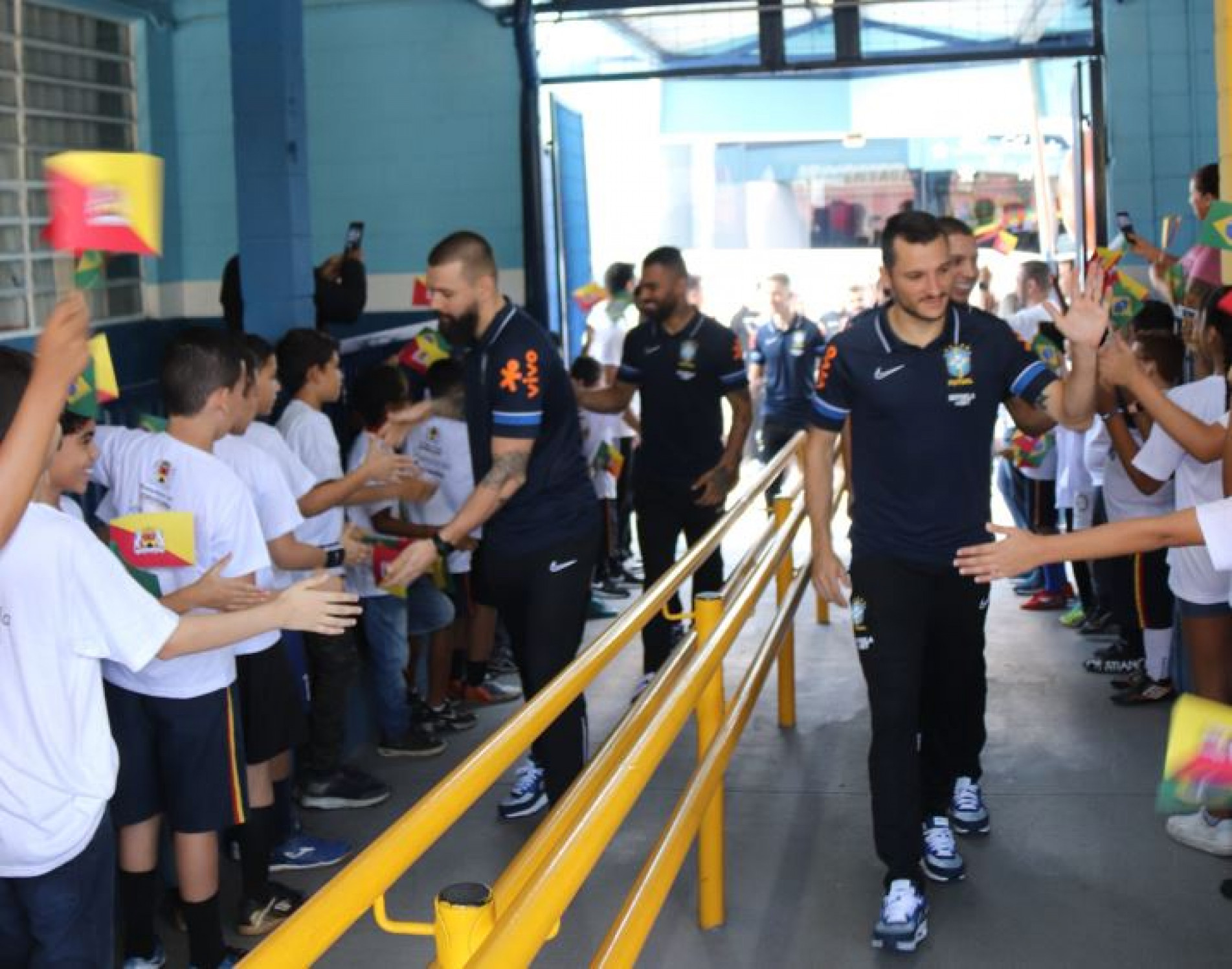 Crianças fizeram um corredor na porta da escola para receber os atletas, igual nos jogos
