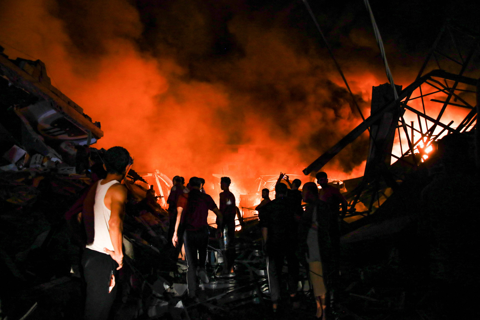 Fogo e fuma&ccedil;a s&atilde;o vistos nos escombros em Gaza