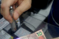 Uma das ferramentas mais comum é a caneta a laser, que faz a "leitura" do dinheiro  - FÁBIO ROGÉRIO (22/12/2023)