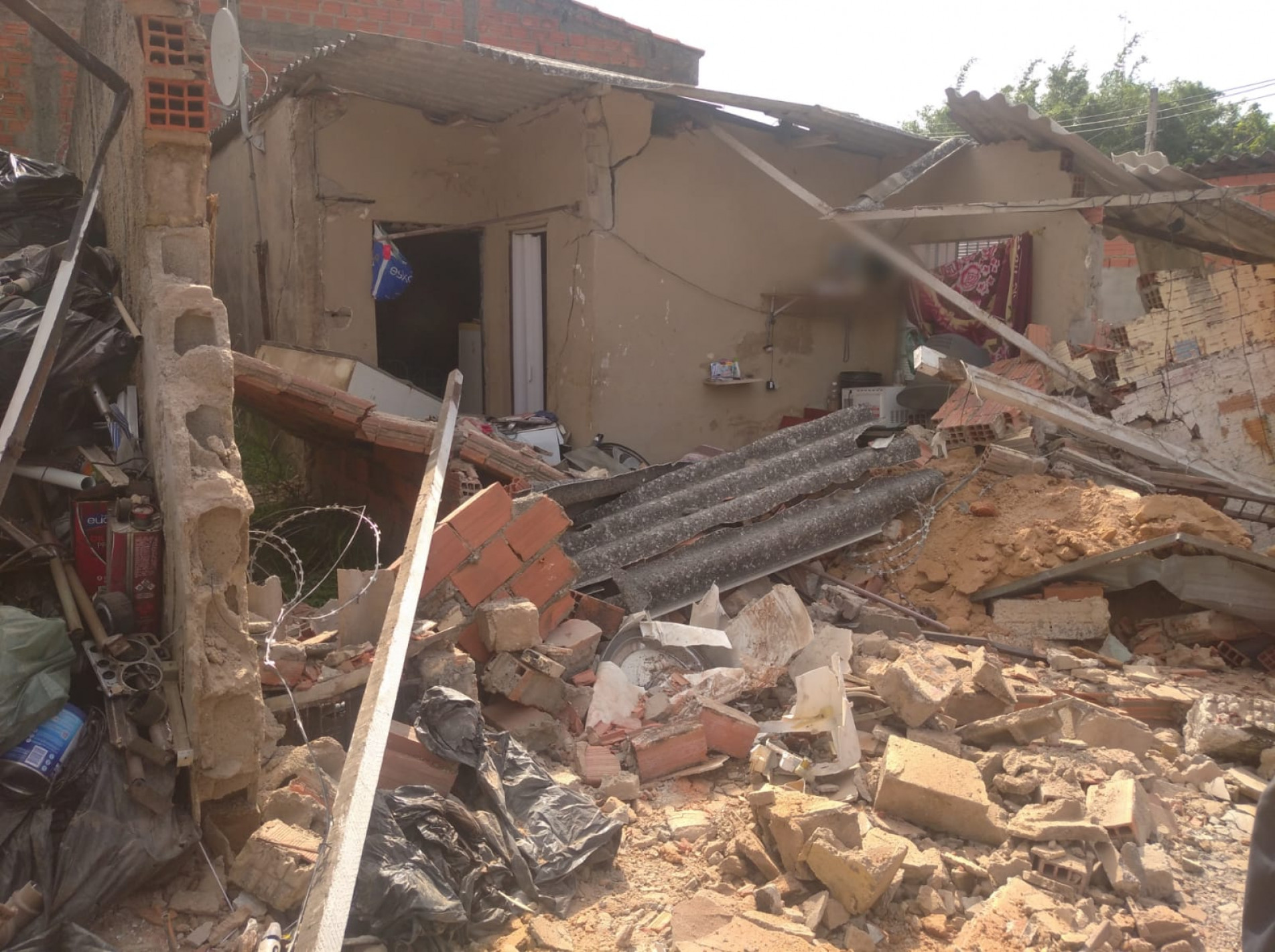 Com o impacto da batida, tijolos e telhas caíram em cima da mulher que ficou presa aos escombros