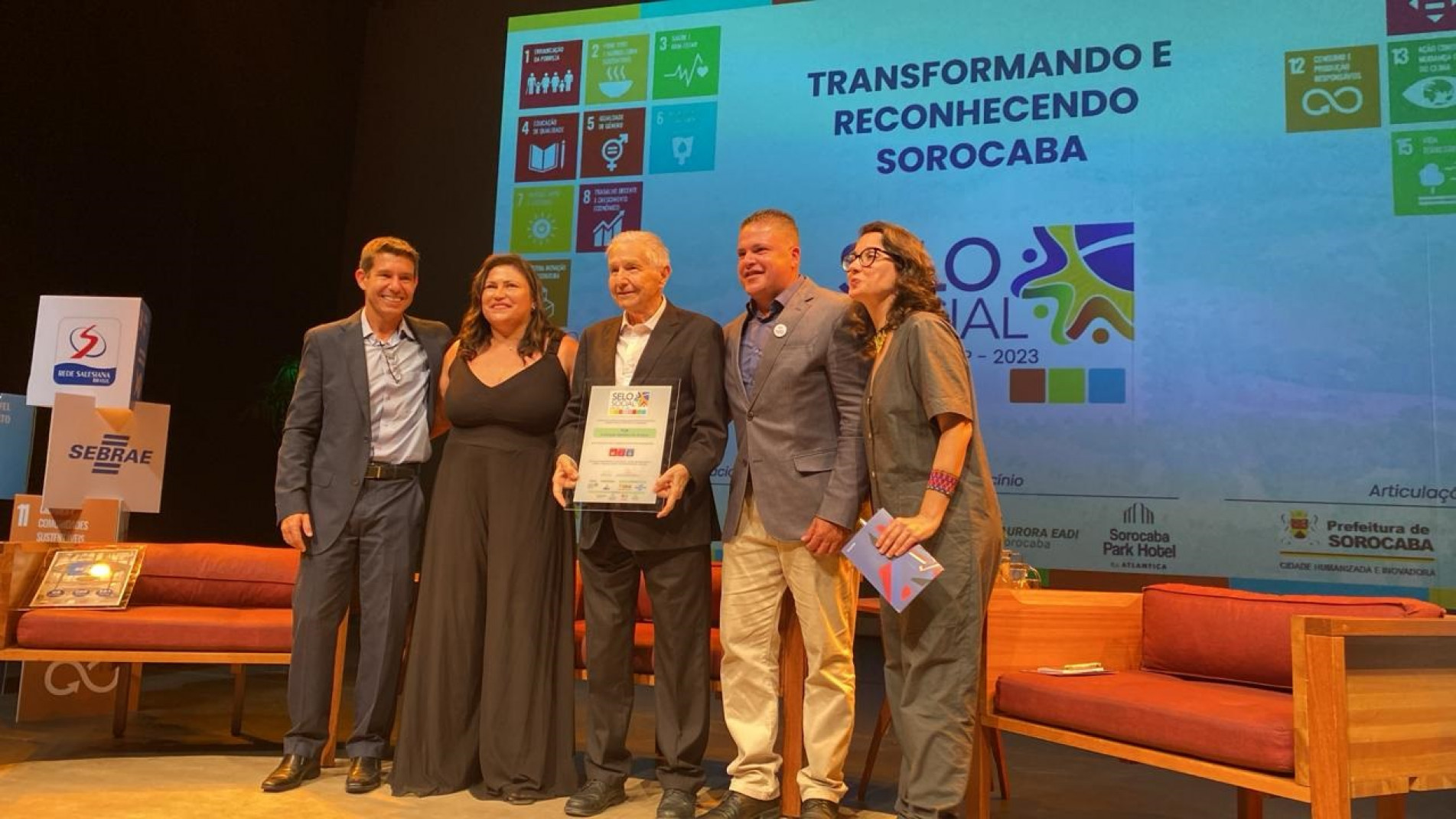 Laelso Rodrigues, com o selo, ladeado por Alexandre Martins (Sebrae), Leda Diniz S. Machado (Fundo Social), Eduardo Barros (Ossel) e Katia Barelli (Sesc)
