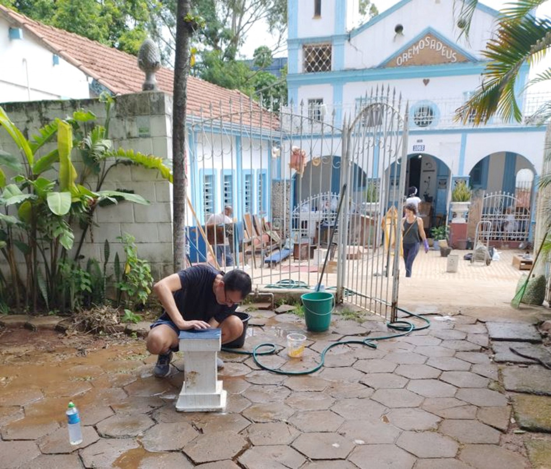 Voluntários trabalham na limpeza da Capela João de Camargo após temporal que provocou o transbordamento do córrego da Água Vermelha e alagou o prédio
