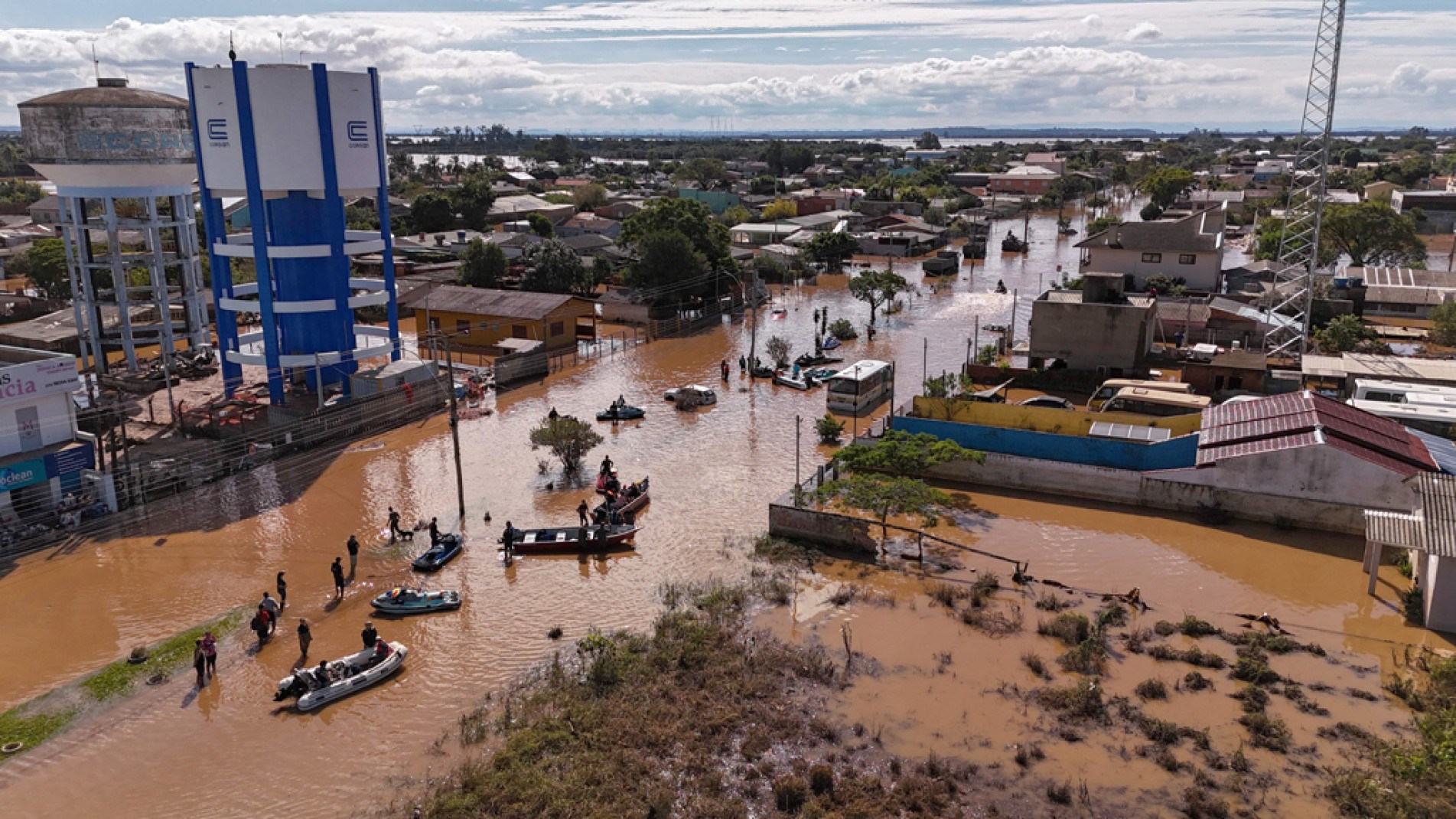 Equipes usam barcos para socorro a pessoas que ainda estão em suas casas