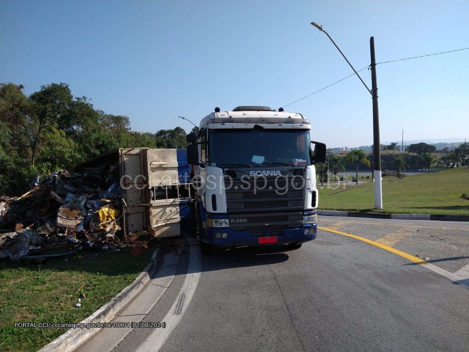 A carga de sucatas caiu no canteiro lateral