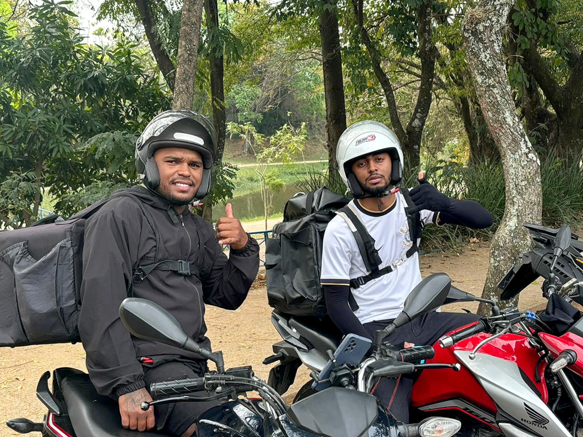 Os motoboys Gleison e Yuri enfrentam o sol usando capacete e ingerindo o máximo de água possível
