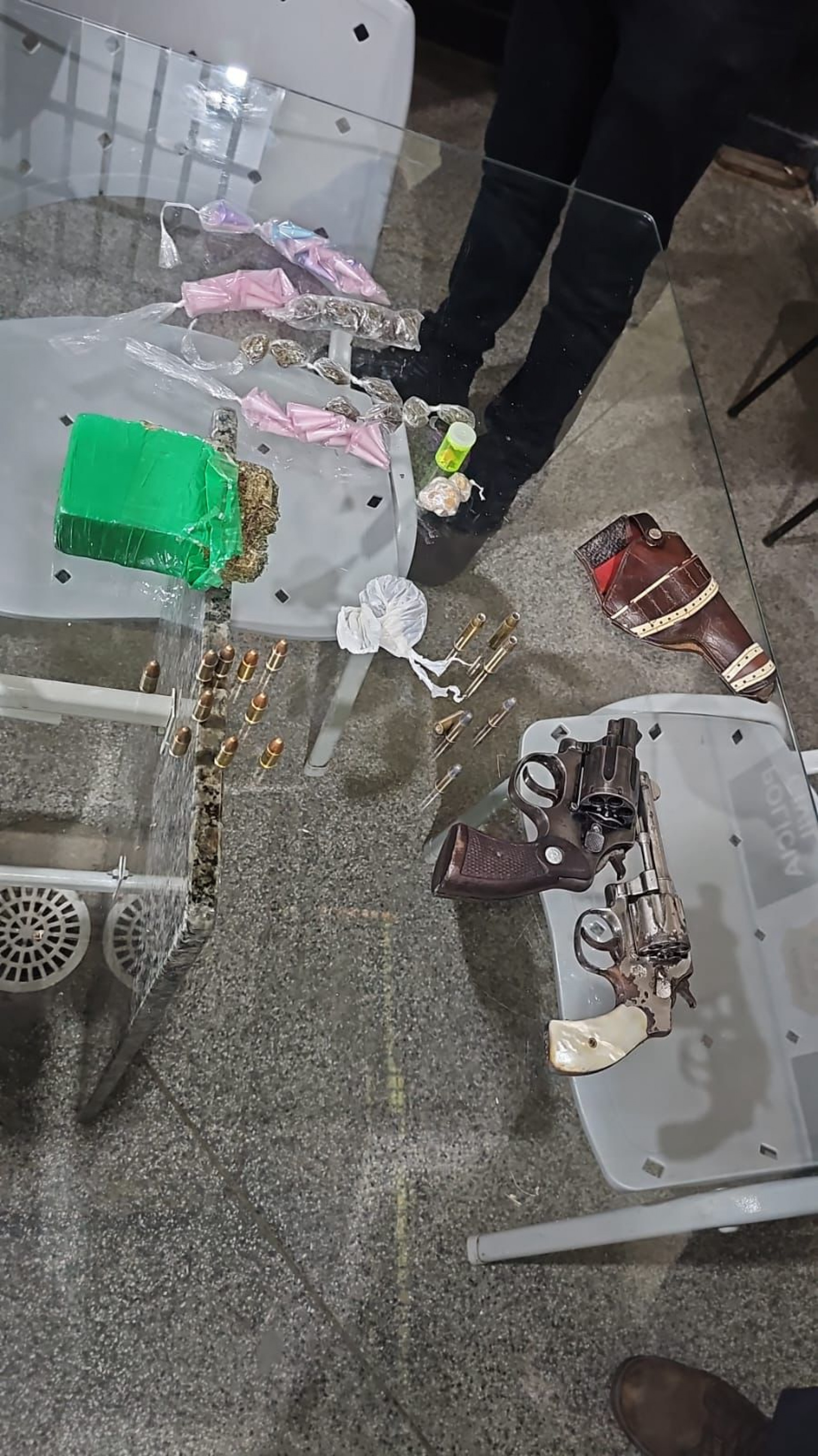 Foram apreendidos dois revólveres, sendo um de calibre 32 e outro de calibre 38, munições, um telefone celular e uma balança de precisão