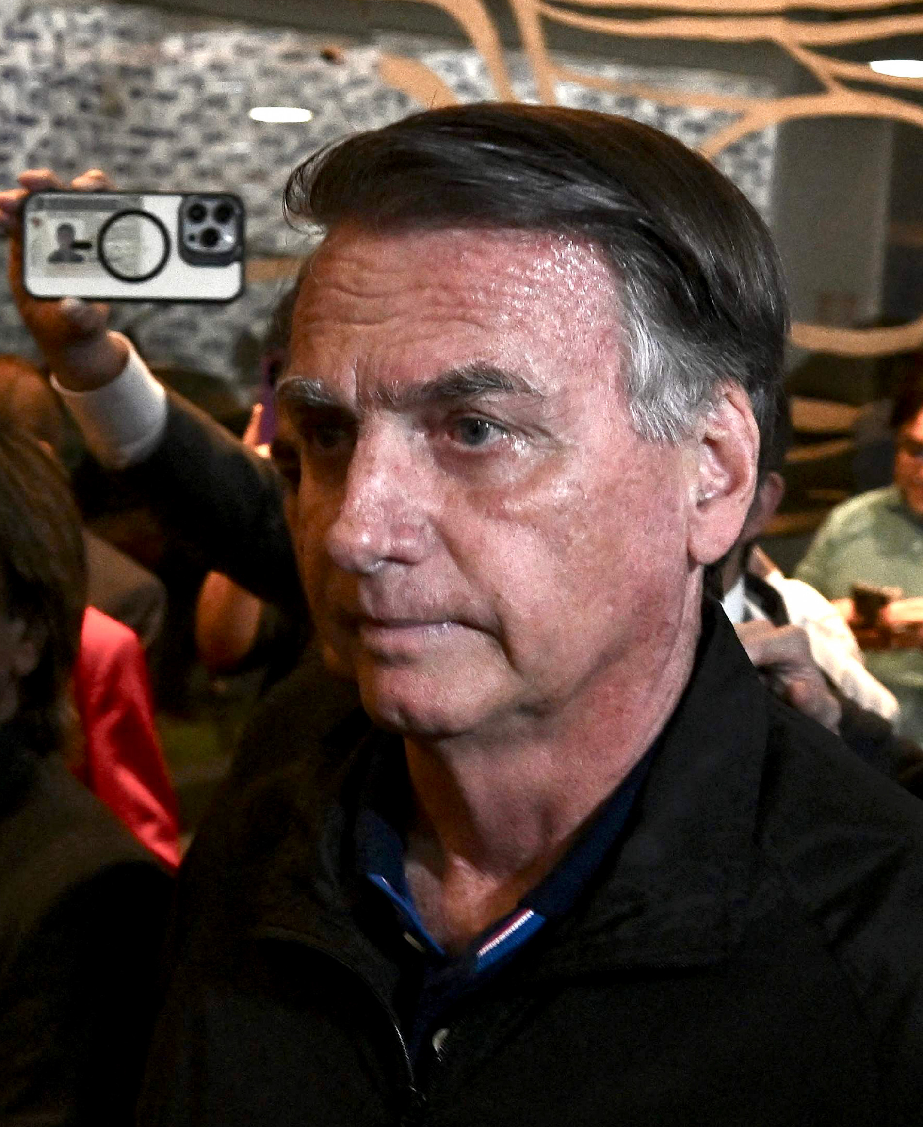 Former Brazilian President Jair Bolsonaro (C) arrives at the National Congress to meet Liberal Party lawmakers in Brasília on July 21, 2025. (Photo by EVARISTO SA / AFP)