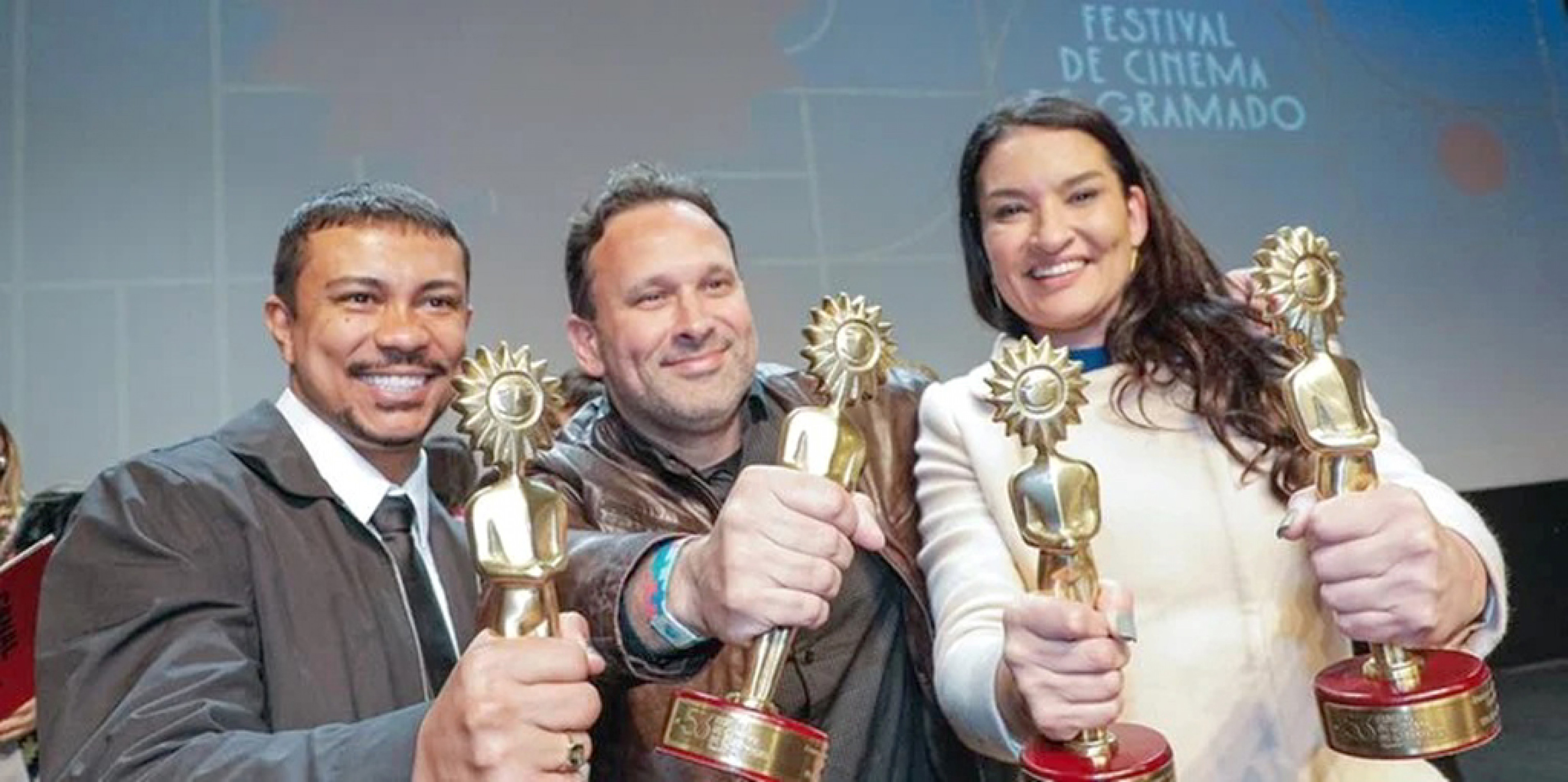 Xamã, o diretor Bruno Bini e a produtora Luciana Druzina recebem o Kikito
