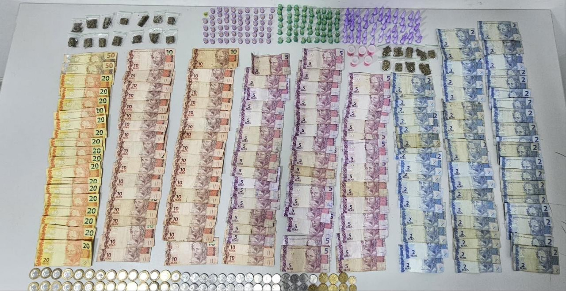 Os policiais encontraram diversas cédulas de dinheiro, totalizando R$ 1.144,95, além de aproximadamente 64 gramas de cocaína, 85 gramas de maconha e 90 gramas de crack