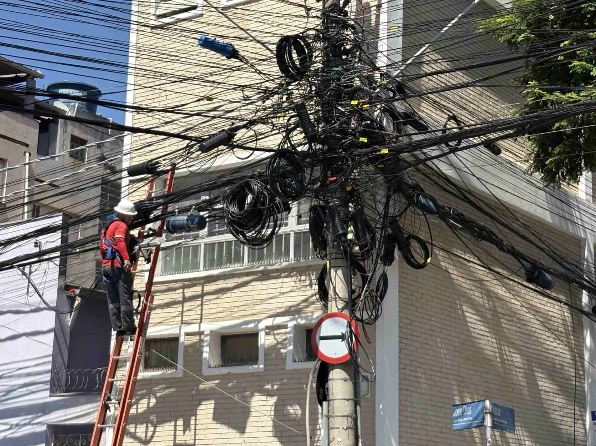 Técnicos trabalham na manutenção da rede na rua Arthur Martins, após incêndio atingir estrutura que concentra fios de diversas operadoras de internet