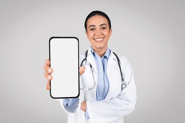 Médica de jaleco mostrando aparelho celular