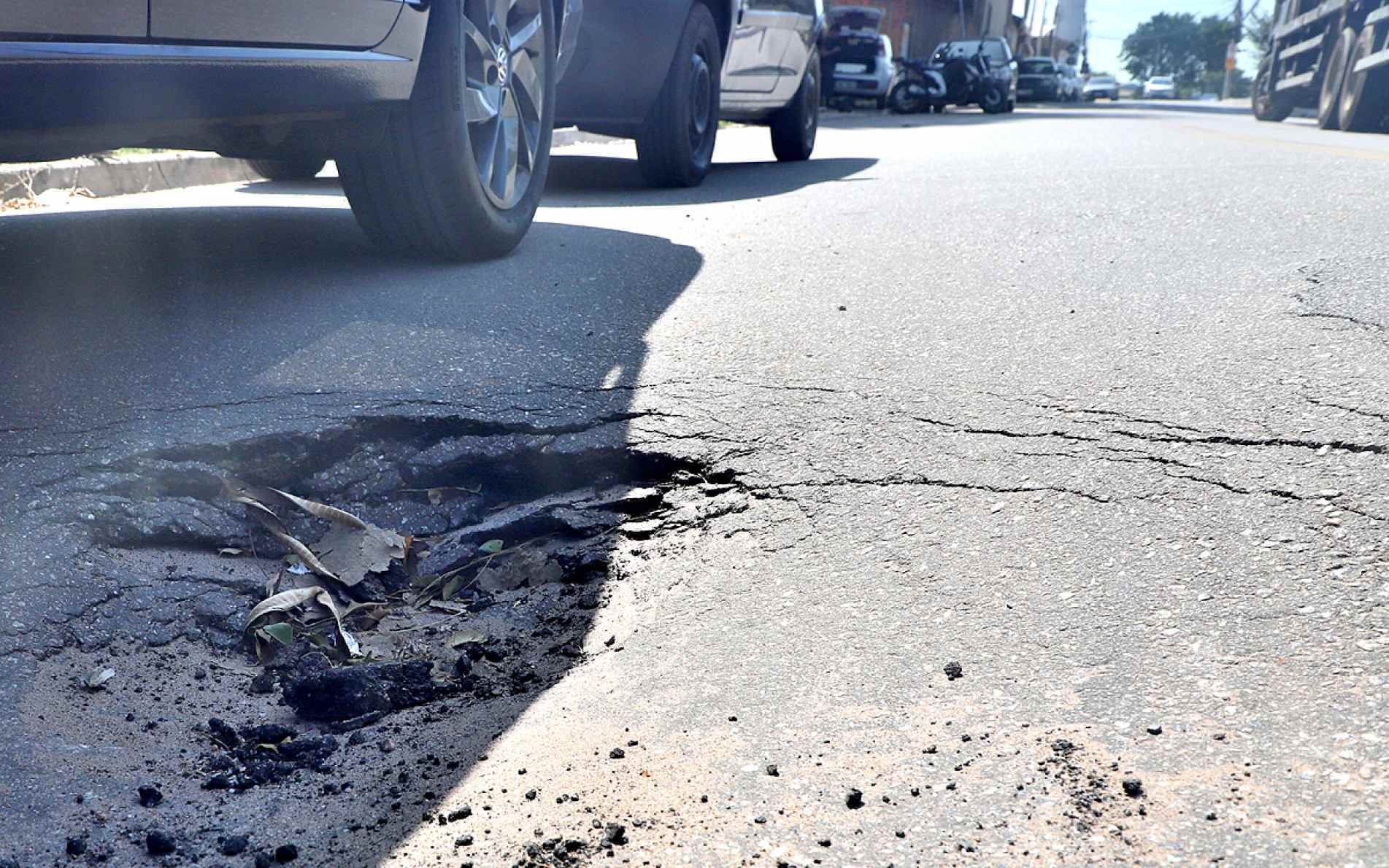 Buracos e irregularidades no asfalto aparecem ao longo da via, recapeada recentemente
