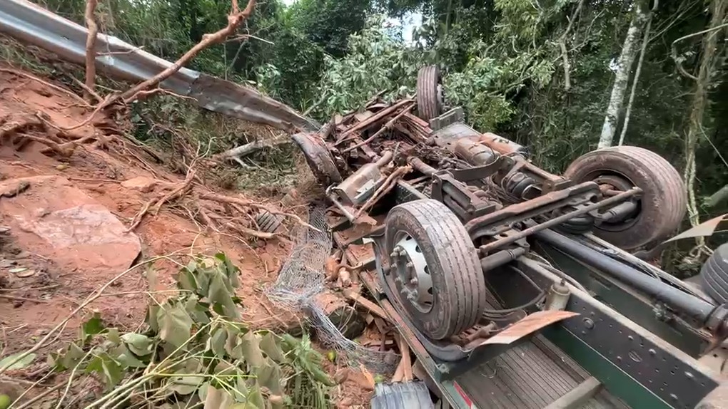Após o impacto, o caminhão caiu na ribanceira e ficou com as rodas para cima, fora da via 
