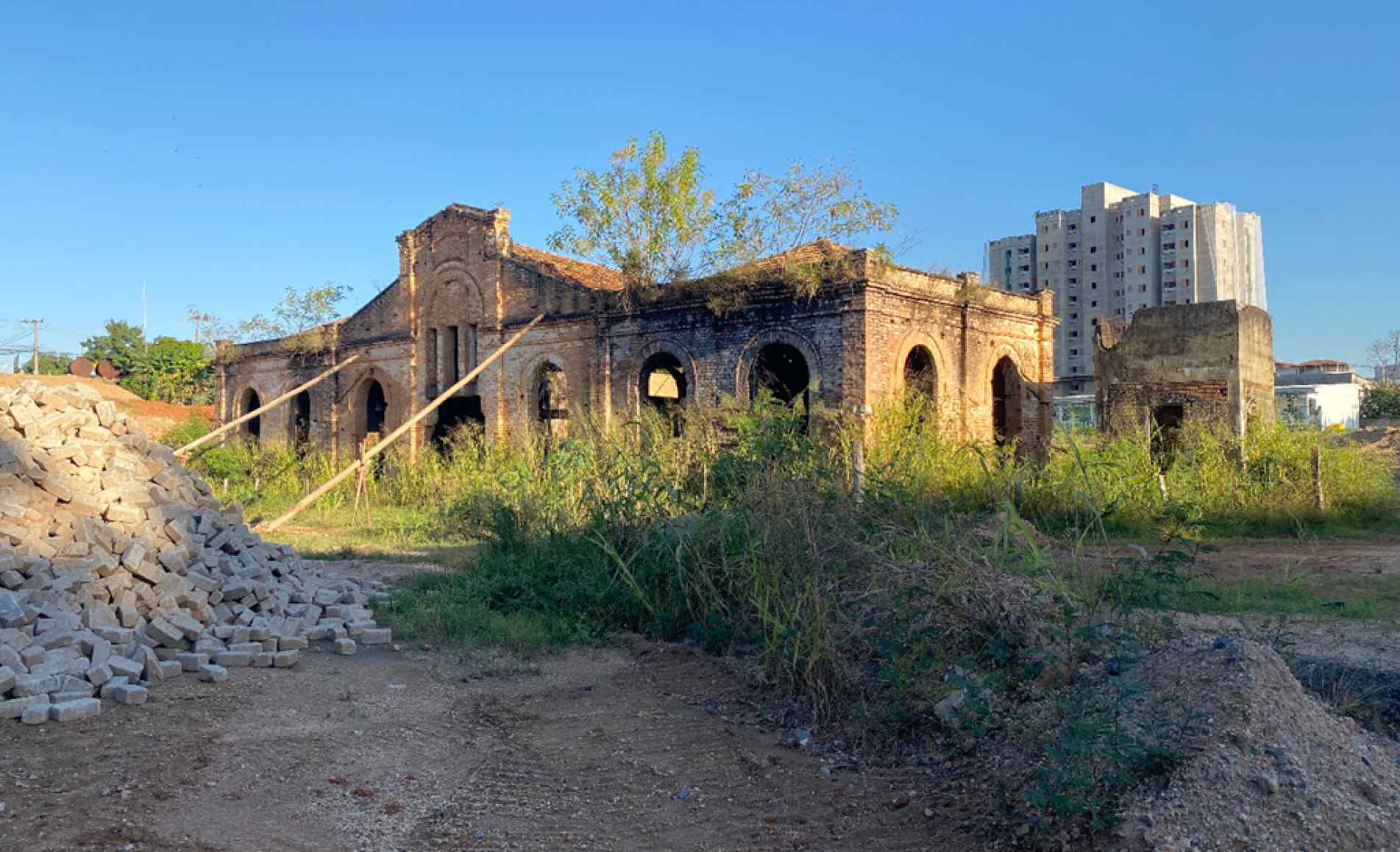  Local tem pilhas de pedras, terra, entulho e materiais armazenados próximos à construção tombada
