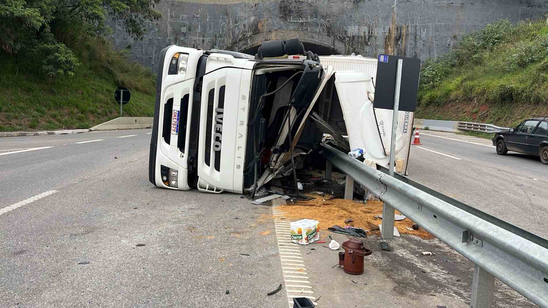 Ao perder o controle em uma curva, o motorista percebeu que a carreta iria tombar e se jogou para o banco do passageiro