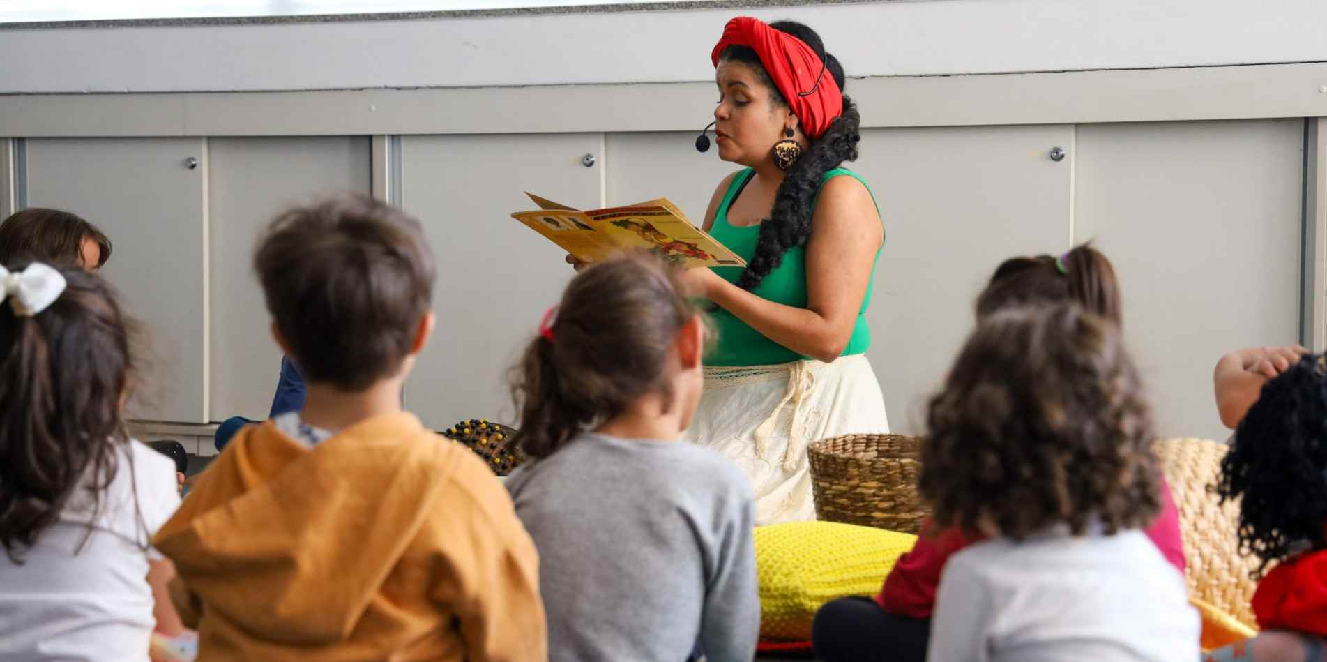 A vivência tem como proposta um convite para as crianças e suas famílias conhecerem e experimentarem com o corpo, escuta e voz, de forma coletiva, histórias contadas e cantadas por meio da riqueza da oralidade, herdada do continente africano no Brasil