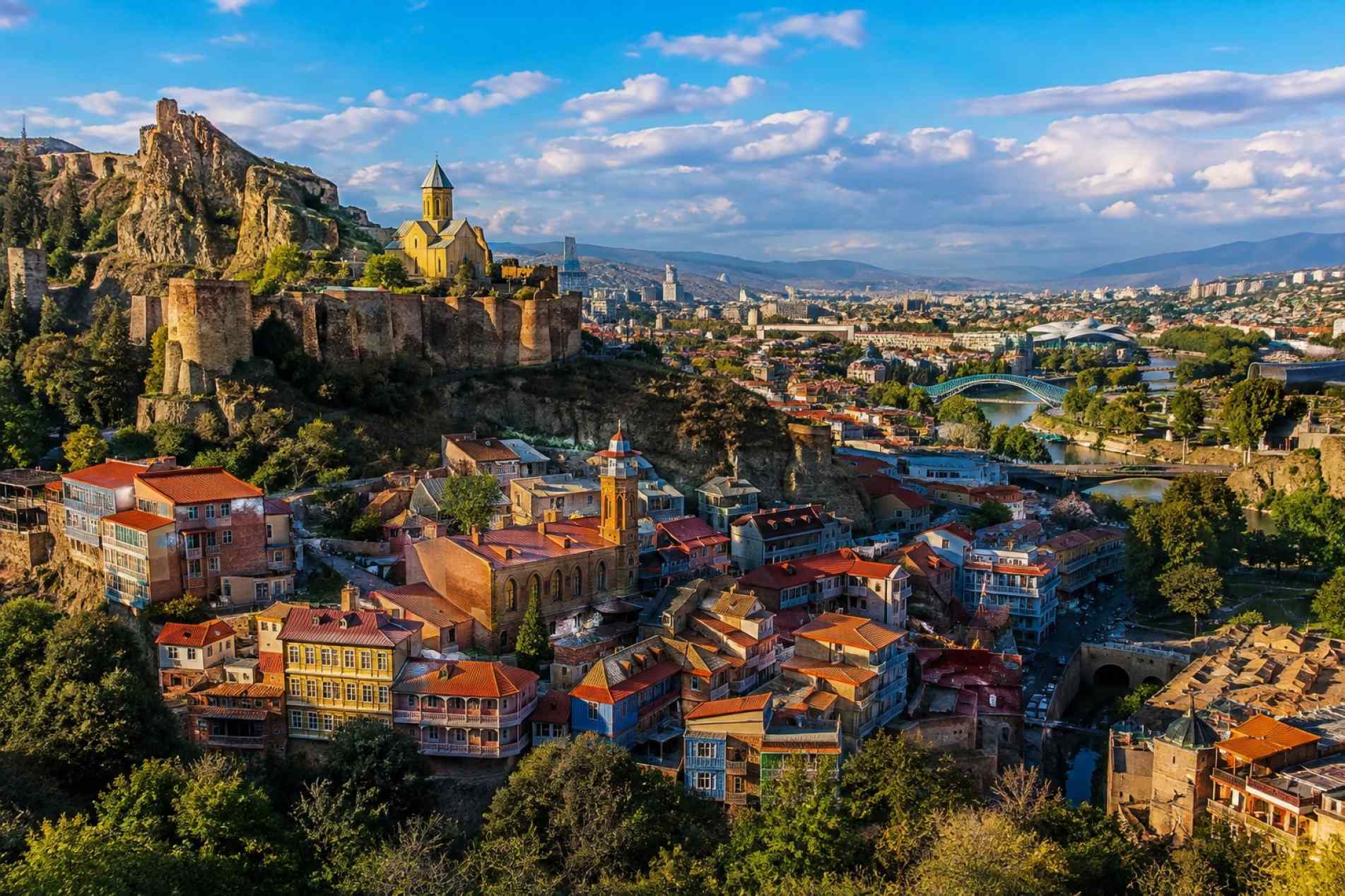 Vista panorâmica de Tbilisi, capital da Geórgia, com a Fortaleza de Narikala, construções históricas e o rio Kura ao fundo