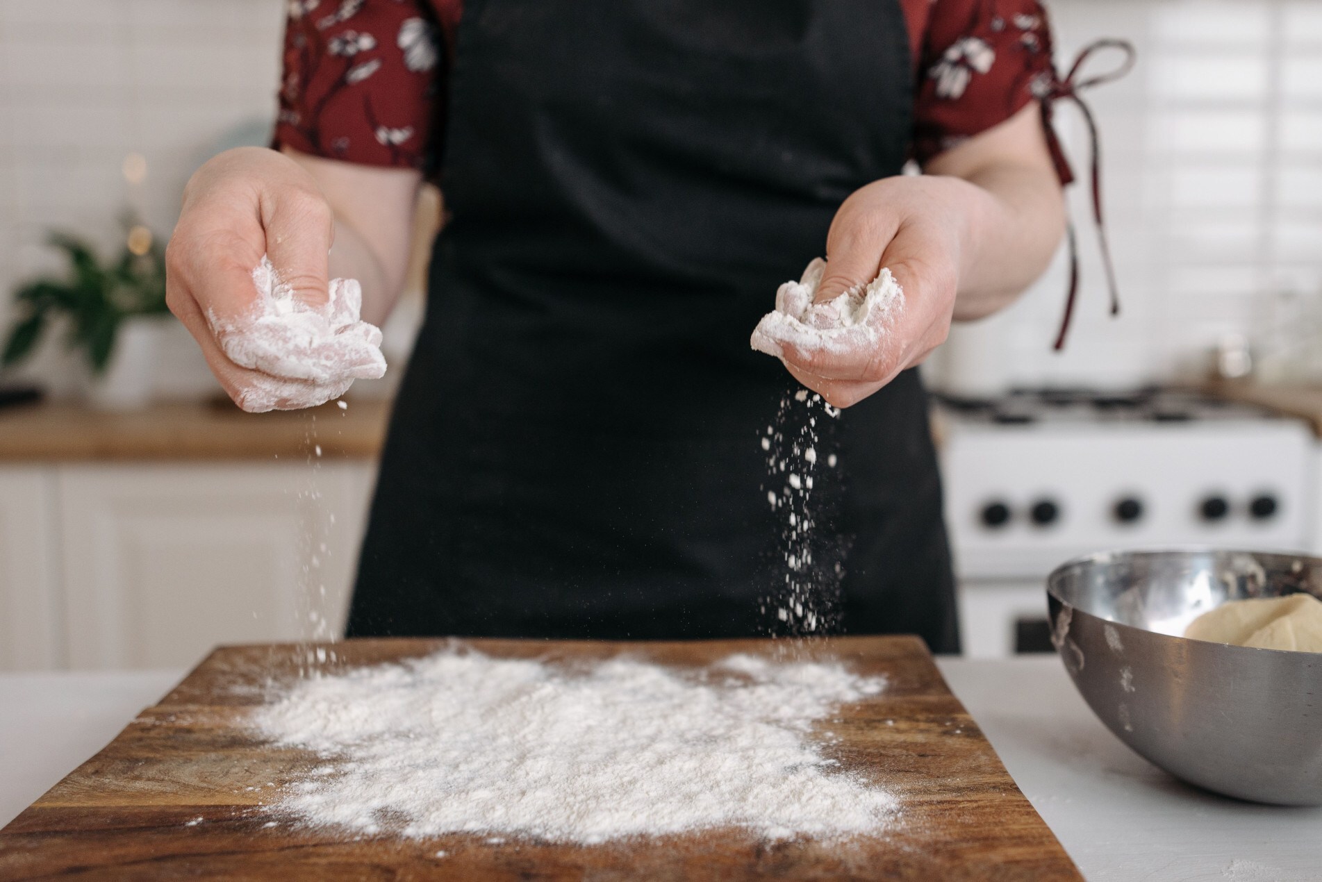 Pessoa manipula farinha na cozinha